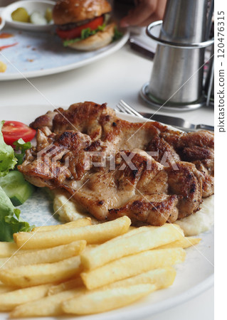 grill chicken meat served with chips and fresh salad on a plate  120476315