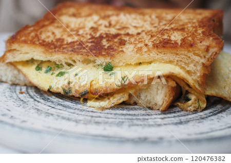 A savory Cloudy Cheese Omelette Sandwich on crispy toast, ideal for any meal or snack 120476382