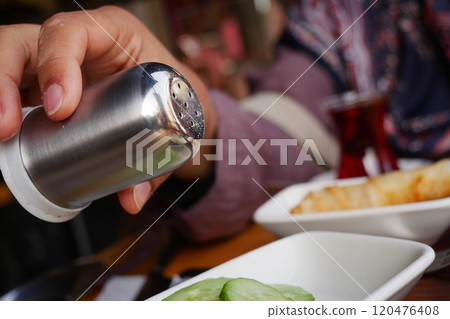 Salt falls from a salt shaker Salt falls from a salt shaker 120476408