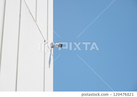 Surveillance Camera Mounted on Building Against Clear Blue Sky Surveillance Camera Mounted on Building Against Clear Blue Sky 120476821