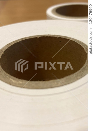 Thermal Printer Paper Rolls.This image displays two white thermal printer paper rolls used for printing receipts and other documents. Each roll has a cardboard core in the center. Thermal Printer Paper Rolls.This image displays two white thermal printer paper rolls used for printing receipts and other documents. Each roll has a cardboard core in the center. 120476940