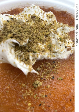 Traditional Turkish Dessert Kunefe with Clotted Cream and Crushed Pistachios.The image shows a portion of Kunefe, a traditional Turkish dessert. The knefe is topped with clotted cream Traditional Turkish Dessert Kunefe with Clotted Cream and Crushed Pistachios.The image shows a portion of Kunefe, a traditional Turkish dessert. The knefe is topped with clotted cream 120477055