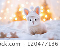 Cute little white rabbit on the bed with Christmas lights background. Selective Focus 120477136