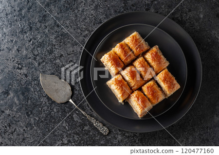 Baklava with walnuts on a blackstone table. 120477160