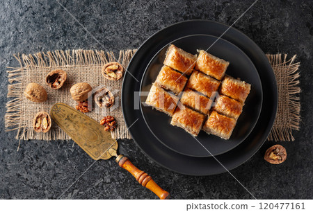 Baklava with walnuts on a blackstone table. Baklava with walnuts on a blackstone table. 120477161