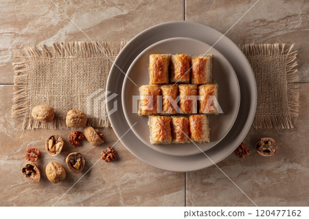 Baklava with walnuts on a beige plate. 120477162
