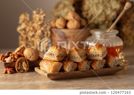 Baklava with walnuts and honey on a beige background. Baklava with walnuts and honey on a beige background. 120477163