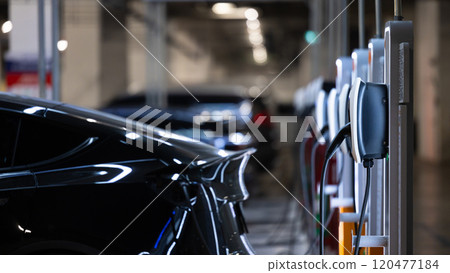 EV charger and electric car, Electric car charger station for charge ev battery, Plug for vehicle with electric engine, EV charger clean energy, Charging point at car parking lot department store. 120477184