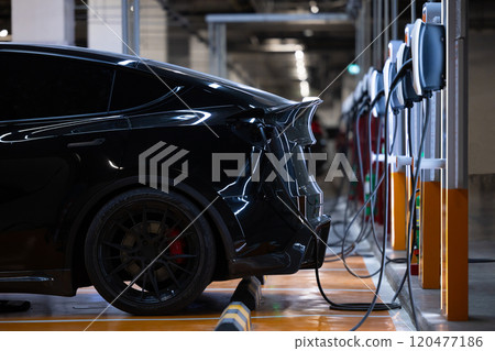 EV charger and electric car, Electric car charger station for charge ev battery, Plug for vehicle with electric engine, EV charger clean energy, Charging point at car parking lot department store. EV charger and electric car, Electric car charger station for charge ev battery, Plug for vehicle with electric engine, EV charger clean energy, Charging point at car parking lot department store. 120477186