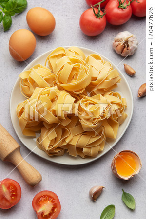 Uncooked pappardelle pasta with ingredients forming frame on table Uncooked pappardelle pasta with ingredients forming frame on table 120477626