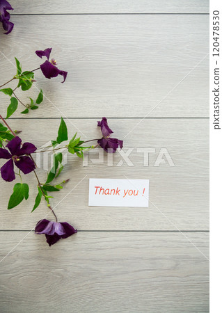 branch of blooming purple clematis, on a light wooden table branch of blooming purple clematis, on a light wooden table 120478530