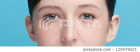 CloseUp of Woman's Blue Eyes With Natural Makeup on blue background, 120479025