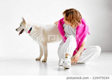 Woman with White Husky in Bright Studio 120479284