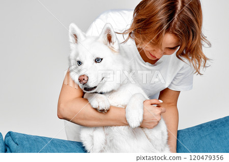 Woman Embracing Her Calm White Husky Woman Embracing Her Calm White Husky 120479356