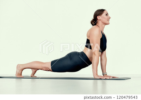 Fit Female Trainer in Upward Dog Pose 120479543