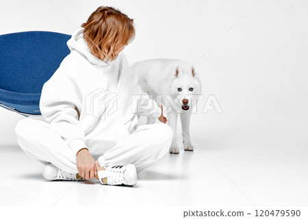 Woman Sitting on Floor with Attentive Husky Dog 120479590