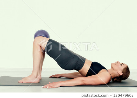 Fitness Instructor Demonstrating Glute Bridge with Ball Fitness Instructor Demonstrating Glute Bridge with Ball 120479602