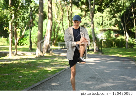 Handsome sportsman stretching leg muscles outdoor in the morning before running Handsome sportsman stretching leg muscles outdoor in the morning before running 120480093