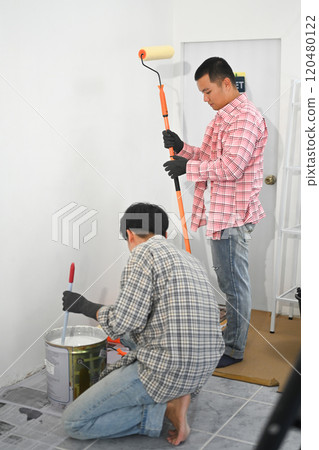 Painters mixing paint and preparing supplies for home renovation Painters mixing paint and preparing supplies for home renovation 120480122