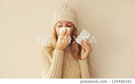 Sick exhausted woman sneezing blow nose using tissue holding pills, unhealthy girl feels unwell Sick exhausted woman sneezing blow nose using tissue holding pills, unhealthy girl feels unwell 120480281