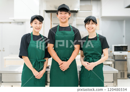 Male and female kitchen staff and cooking staff in the kitchen and back room 120480334