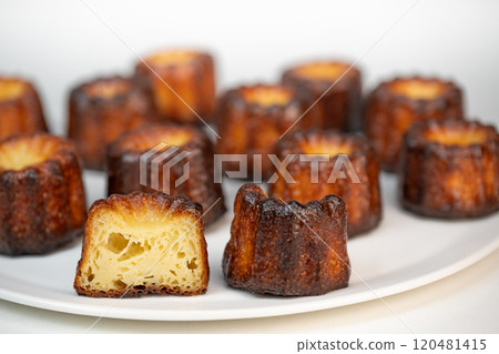 Canneles de bordeaux, traditional French sweet dessert with white table background Canneles de bordeaux, traditional French sweet dessert with white table background 120481415