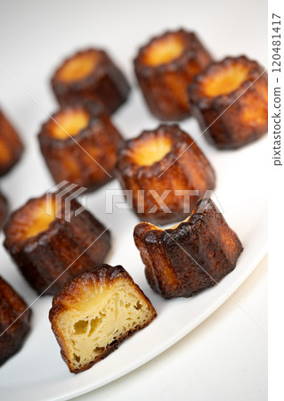 Canneles de bordeaux, traditional French sweet dessert with white table background Canneles de bordeaux, traditional French sweet dessert with white table background 120481417