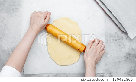 Woman rolling out dough. Making different shapes of fall cookies for Halloween Woman rolling out dough. Making different shapes of fall cookies for Halloween 120481866
