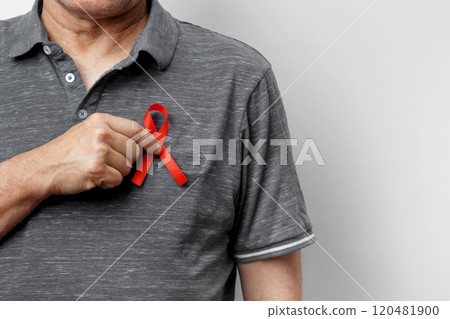 Man holding red AIDS awareness ribbon. World AIDS Day 120481900