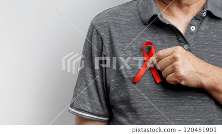 World AIDS Day. Man holding red AIDS awareness ribbon 120481901