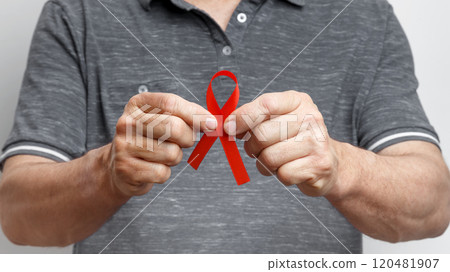 World AIDS Day. Man holding red AIDS awareness ribbon World AIDS Day. Man holding red AIDS awareness ribbon 120481907