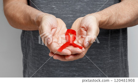 World AIDS Day. Man holding red AIDS awareness ribbon World AIDS Day. Man holding red AIDS awareness ribbon 120481908