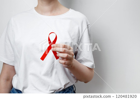 Woman holding red AIDS awareness ribbon. World AIDS Day Woman holding red AIDS awareness ribbon. World AIDS Day 120481920