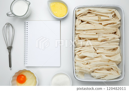 Cooking ingredients and notebook on a white background. For baking Crinkle Cake. Mockup design for recipe or food blog 120482011