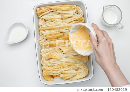 Baked phyllo dough for Crinkle Cake, mixing egg, milk and sugar to make custard 120482019