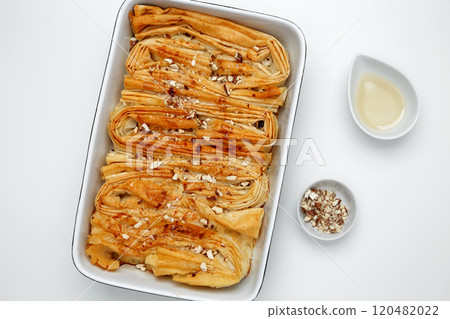 Finished Crinkle Cake made from phyllo dough glazed with sugar syrup and sprinkled with pecans 120482022