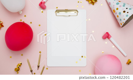 Concept of festive birthday celebrations. Blank card surrounded by colorful balloons, party hats, candles, confetti 120482201