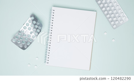 Concept of medicine, healthcare, and pharmaceutical industry. Blister of tablets with pills and blank notebook 120482290