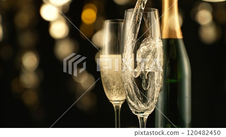 Pouring Champagne Wine into Glass, Isolated on Black Background. Pouring Champagne Wine into Glass, Isolated on Black Background. 120482450