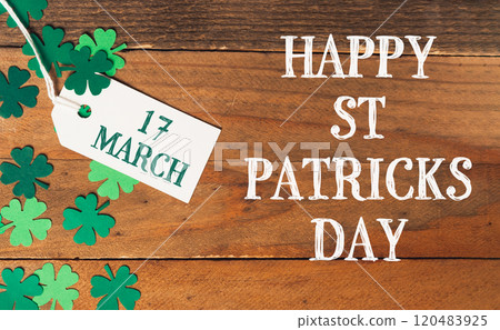 A wooden background with a white tag that says Happy St 120483925