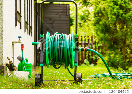 Garden hose for watering plants in garden Garden hose for watering plants in garden 120484435