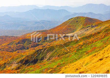 Mount Kurikoma, which straddles the three prefectures of Miyagi, Iwate, and Akita, features a view of the vibrant autumn foliage covering the slopes from the summit. Mount Kurikoma, which straddles the three prefectures of Miyagi, Iwate, and Akita, features a view of the vibrant autumn foliage covering the slopes from the summit. 120484695