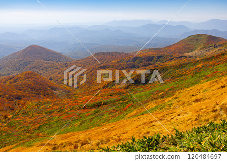 Mount Kurikoma, which straddles the three prefectures of Miyagi, Iwate, and Akita, features a view of the vibrant autumn foliage covering the slopes from the summit. Mount Kurikoma, which straddles the three prefectures of Miyagi, Iwate, and Akita, features a view of the vibrant autumn foliage covering the slopes from the summit. 120484697