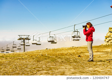 Woman with camera in mountains take travel photo 120484747