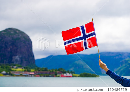 Tourist with norwegian flag on fjord Tourist with norwegian flag on fjord 120484759
