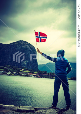 Tourist with norwegian flag on fjord Tourist with norwegian flag on fjord 120484760