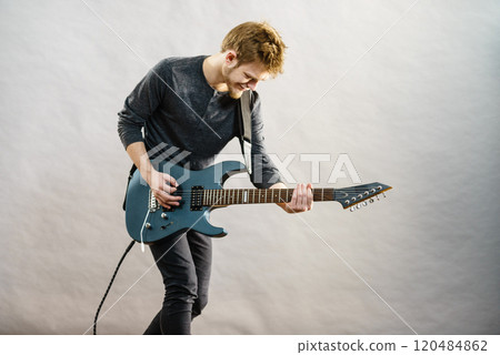 Young man playing electric guitar 120484862