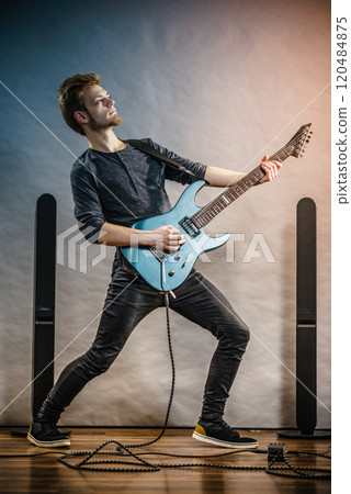Young man playing electric guitar 120484875