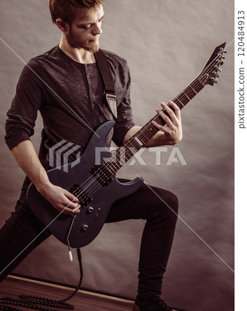Young man playing electric guitar Young man playing electric guitar 120484913