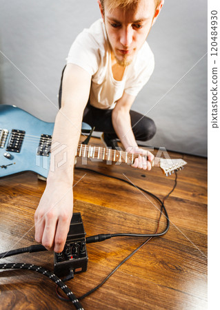 Man setting up guitar equipment Man setting up guitar equipment 120484930